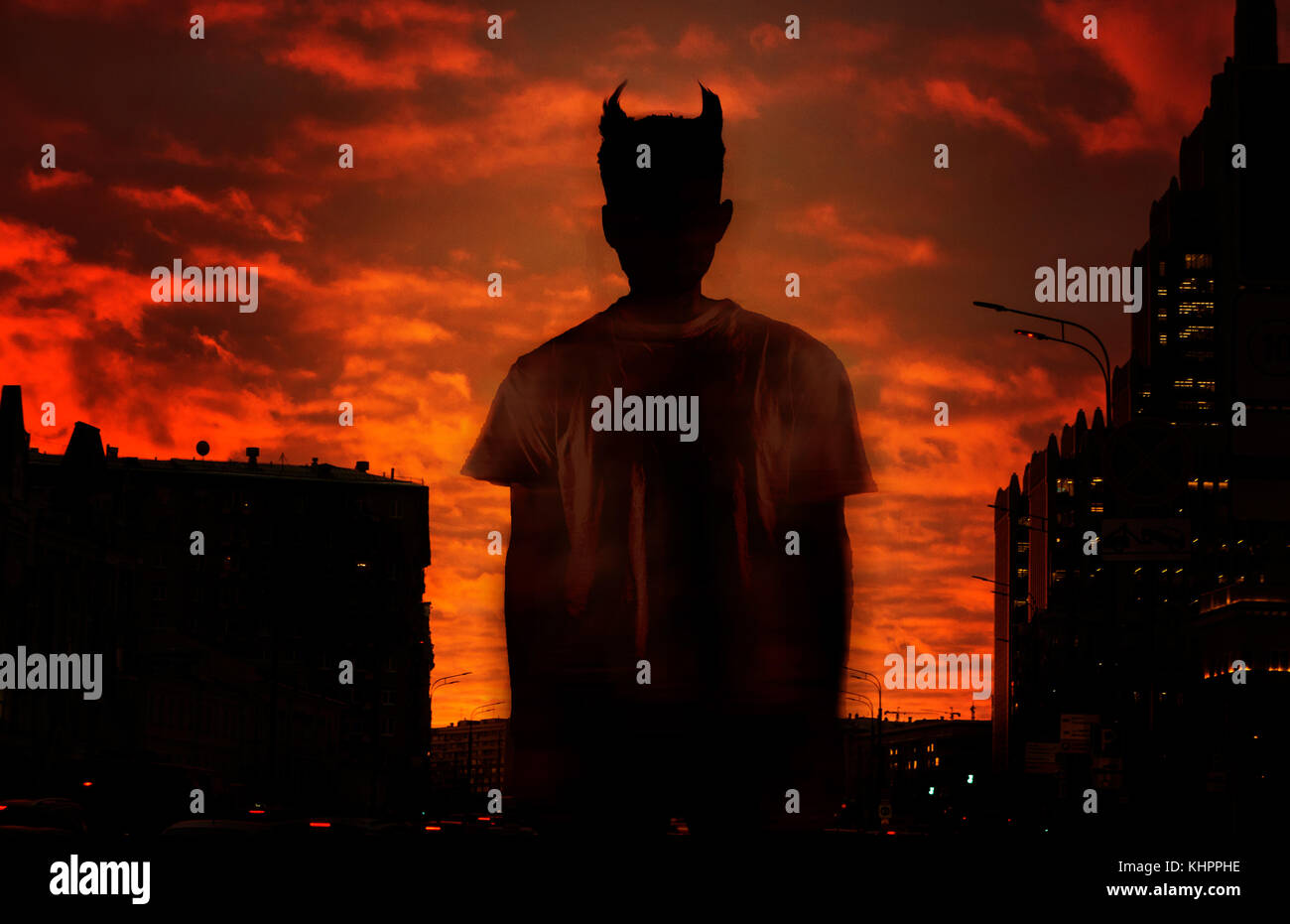 silhouette of the devil on the background of the red bloody sky Stock Photo