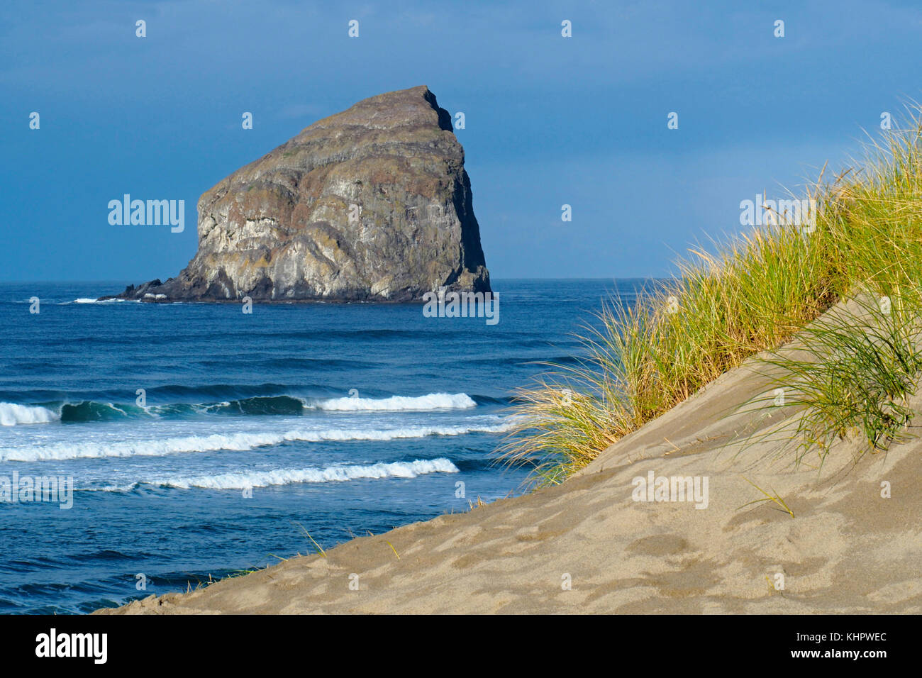 Beach and sand dunes on Cape Kiwanda at Pacific City wih large sea stack rock formation (Haystack or Chief Kiawanda Rock) offshore. Stock Photo
