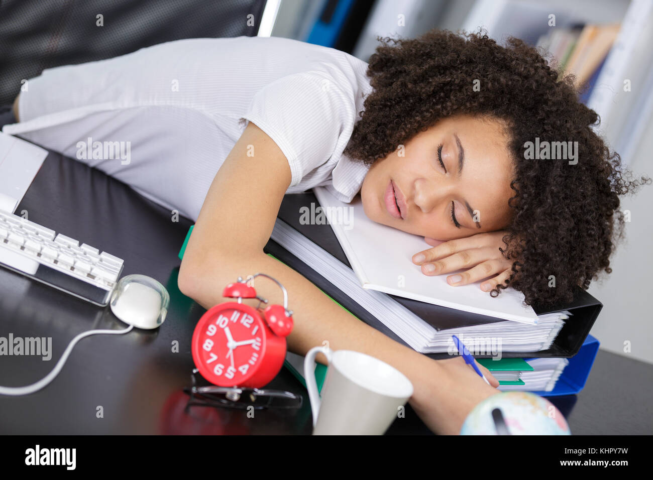 a woman sleeps over books Stock Photo