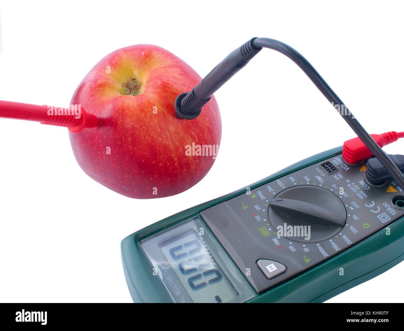 Digital multimeter electrical measuring equipment with apple. Stock Photo