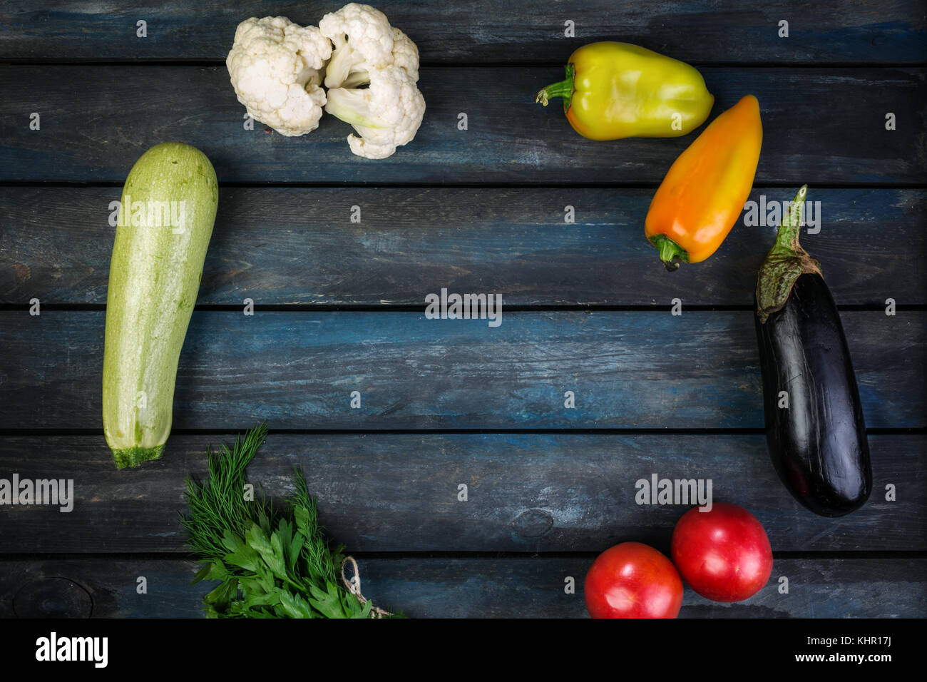 Ingredients for grilled vegetables salad with zucchini, eggplant, onions, peppers and tomato. On a colored wooden background. Top view Stock Photo