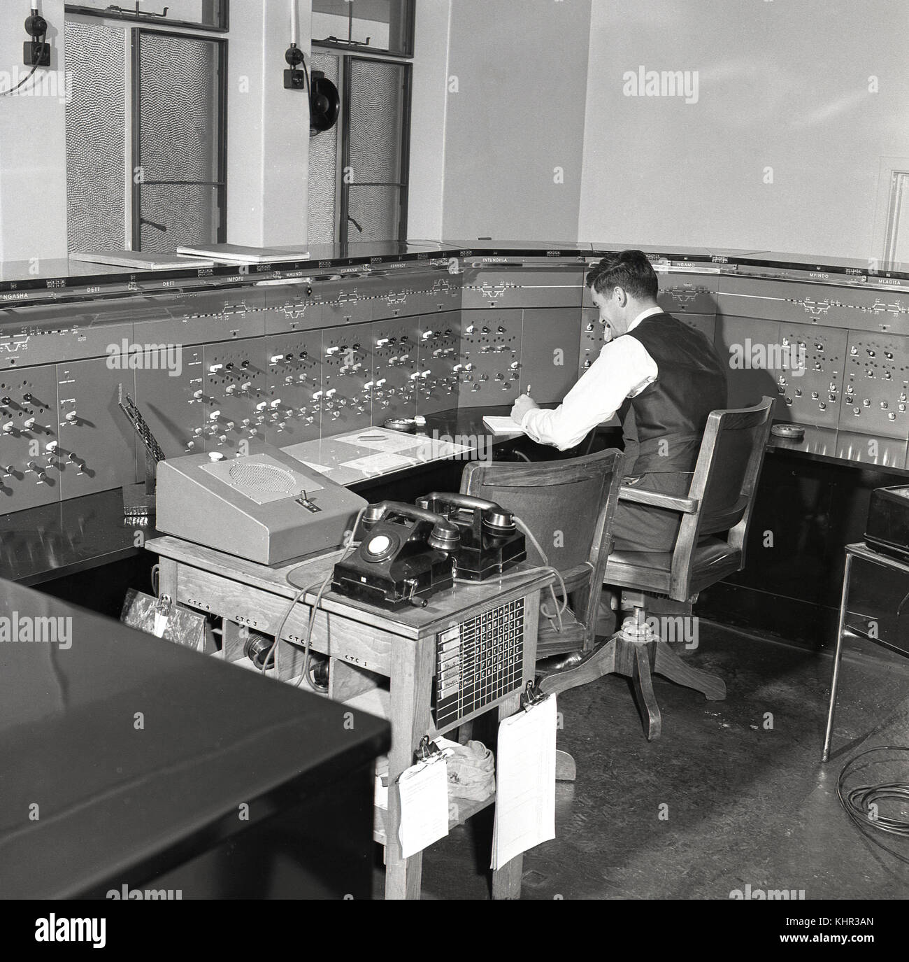 1950s, historical, male railway signal operator sitting at the control