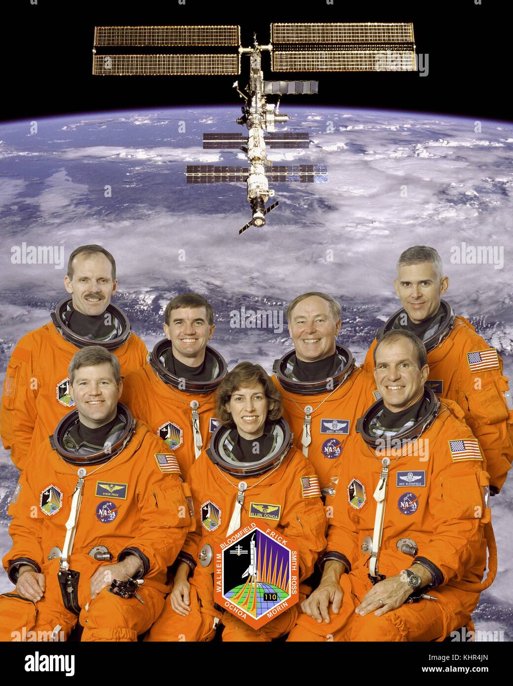 Official NASA portrait of Space Shuttle Atlantis STS-110 International Space Station mission prime crew astronauts (back, L-R) Steven Smith, Rex Walheim, Jerry Ross, Lee Morin, (front, L-R) Stephen Frick, Ellen Ochoa, and Michael Bloomfield in orange launch and entry spacesuits at the Johnson Space Center December 16, 2001 in Houston, Texas.  (photo by NASA Photo via Planetpix) Stock Photo
