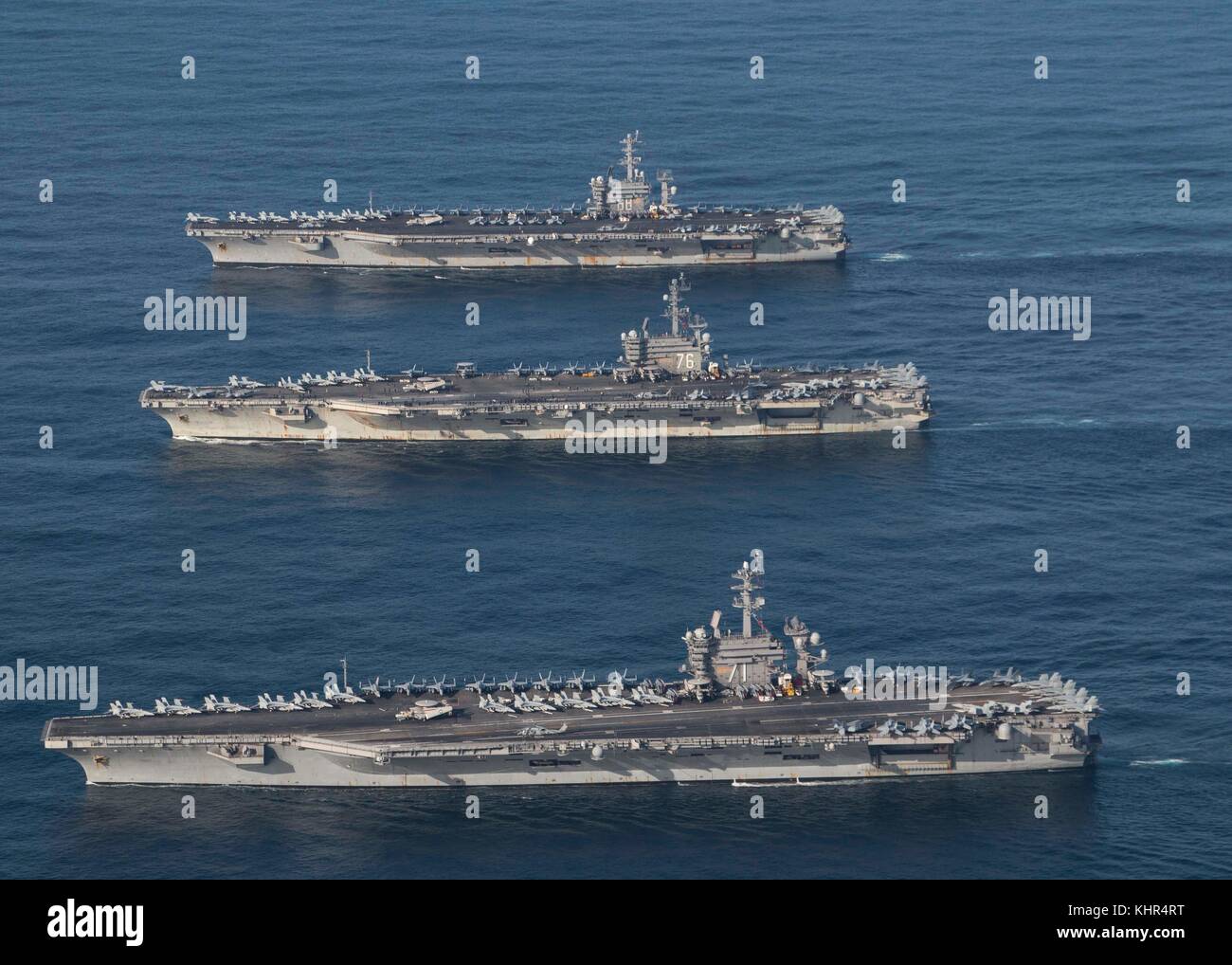 The U.S. Navy Nimitz-class aircraft carriers (top to bottom) USS Nimitz, USS Ronald Reagan, and USS Theodore Roosevelt steam in formation November 12, 2017 in the Pacific Ocean.  (photo by James Griffin via Planetpix) Stock Photo