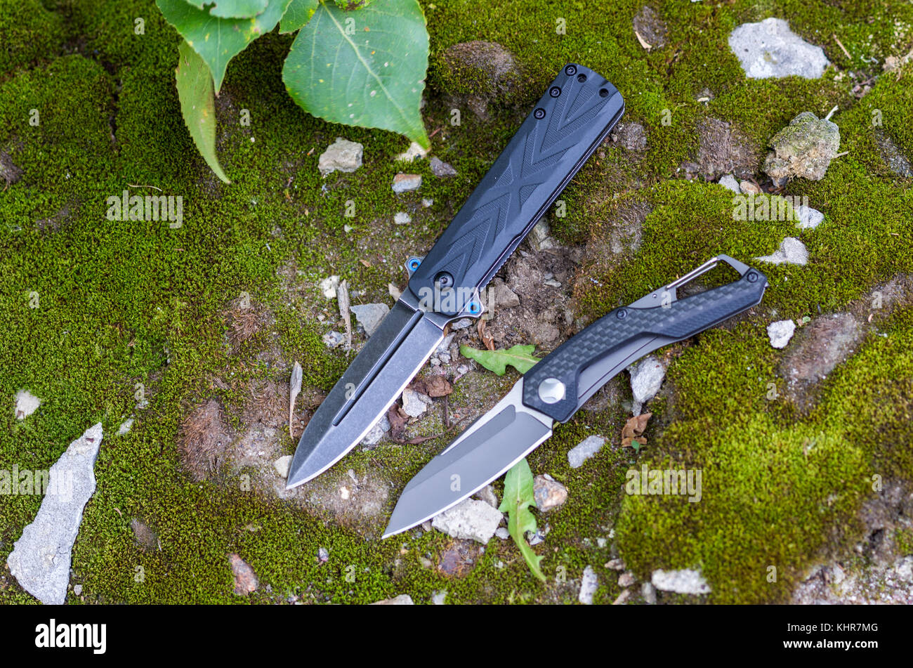 Two folding knives. Knives with different handles. Photo on the background of moss Stock Photo