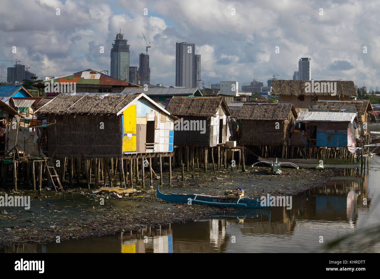 Buildings made of light materials on wooden stilts are home to the Badjao community on the outskirts of Cebu City,Philippines.Modern buildings within  Stock Photo