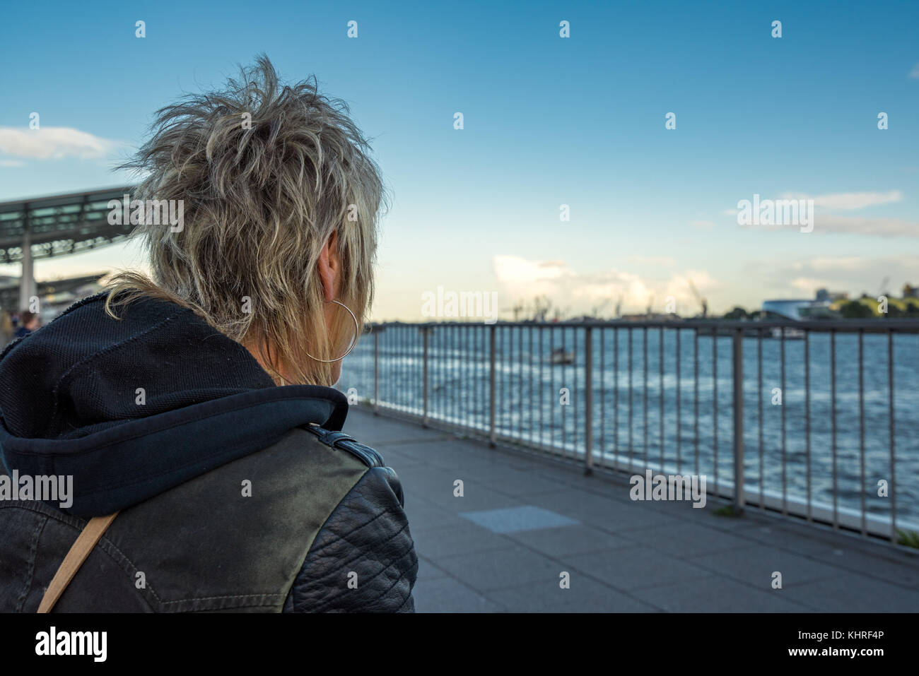 Frau blickt von den Landungsbrücken auf den Hamburger Hafen Stock Photo
