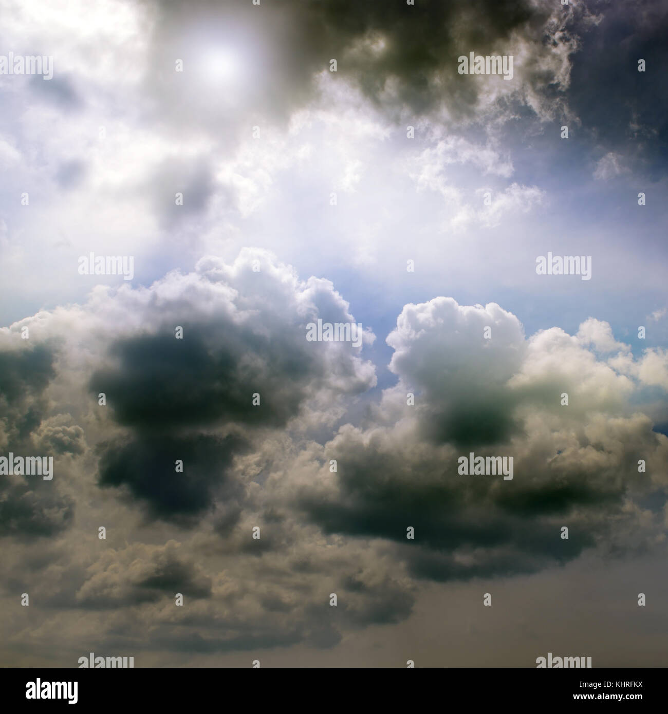 Overcast sky and the sun behind cumulus clouds. Stock Photo
