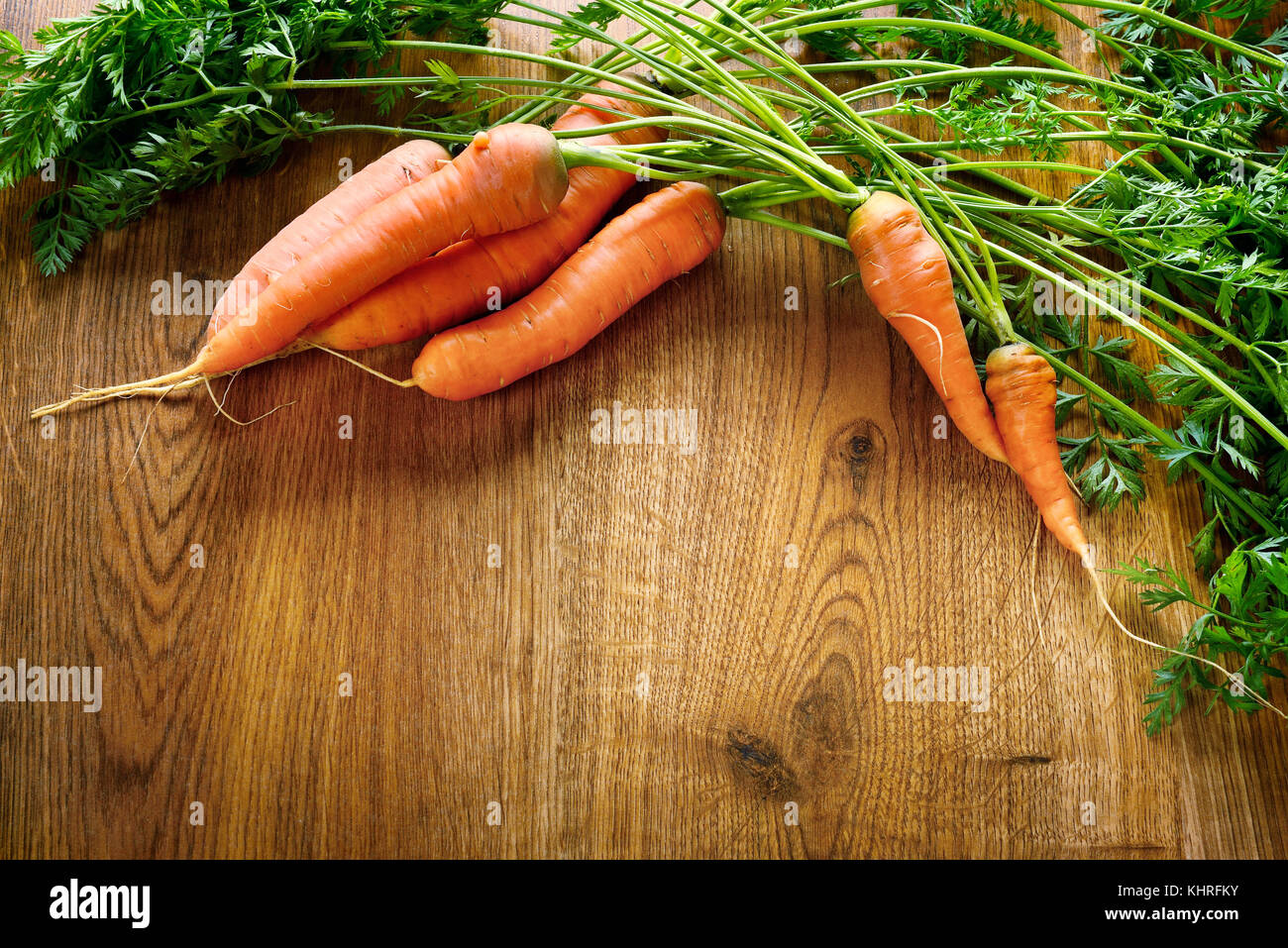 Fresh carrots on wooden table in kitchen. Healthy ecofriendly food