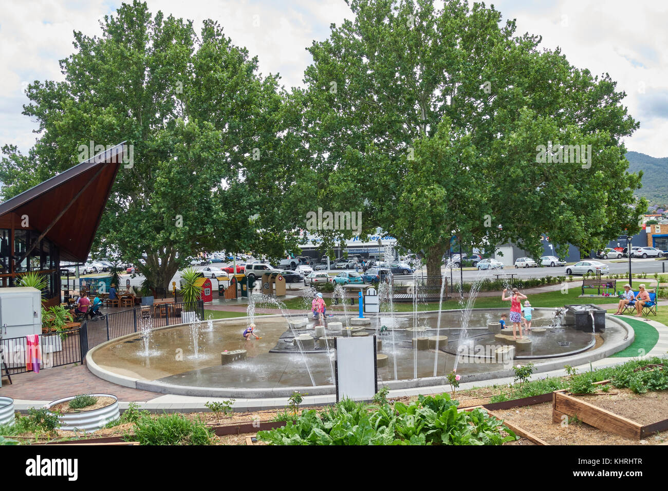 Children's splash pad with kitchen garden in foreground and London Plane trees for shade. Tamworth NSW Australia. Stock Photo
