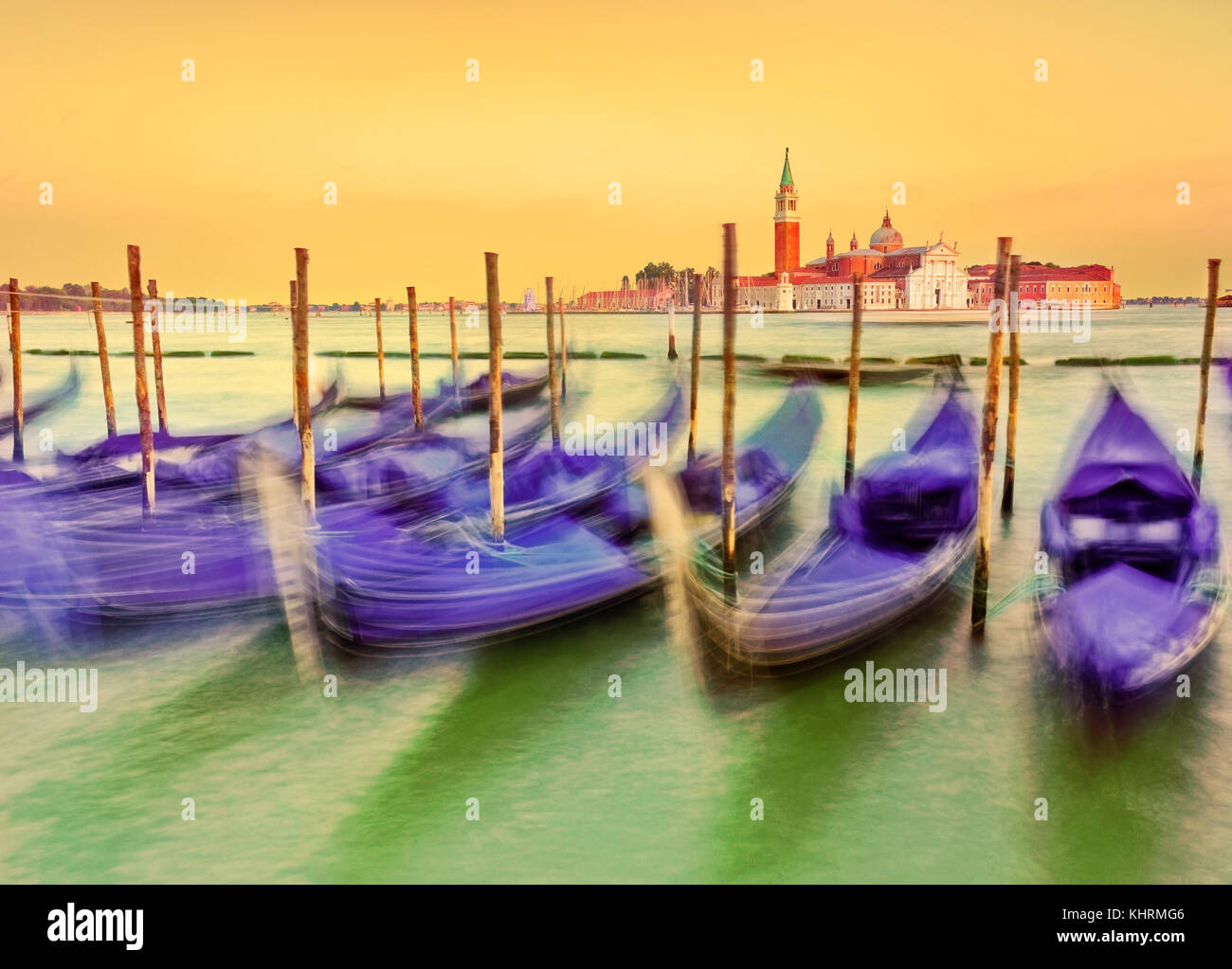 Gondolas moving along the wave on the Grand Canal in Venice at sunset ...