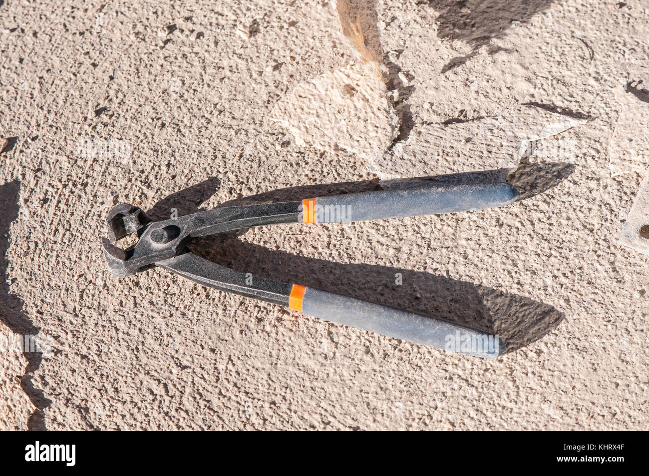 masonry pair of pincers on a concrete flloor Stock Photo