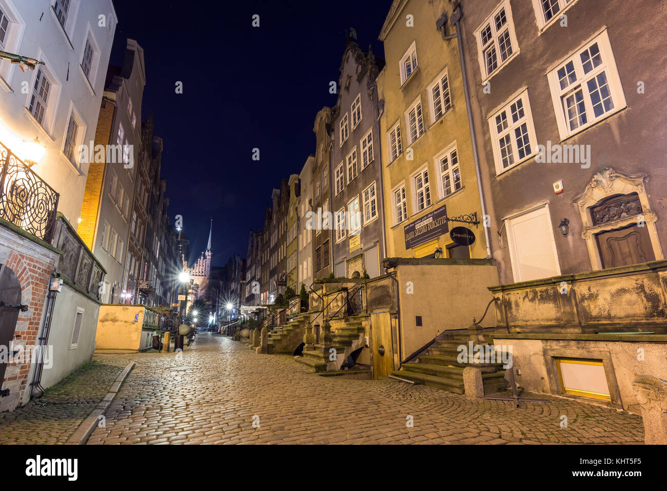 View of old buildings on the empty St. Mary's Street (ul. Mariacka) and St. Mary's Church at Main Town (Old Town) in Gdansk, Poland, in the evening. Stock Photo
