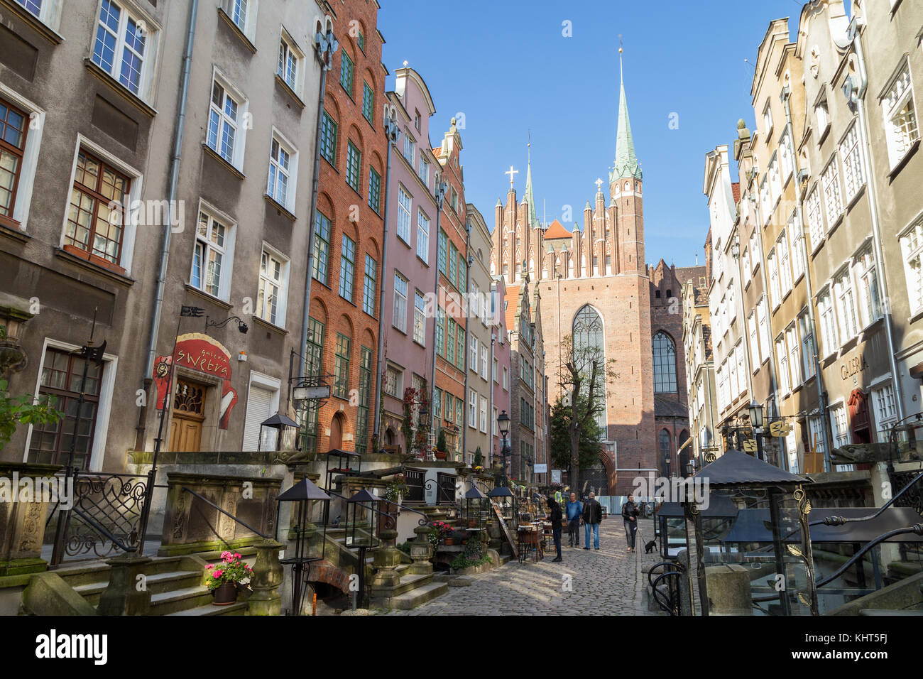 View of old buildings on the St. Mary's Street (ul. Mariacka) and St. Mary's Church at the Main Town (Old Town) in Gdansk, Poland, on a sunny day. Stock Photo