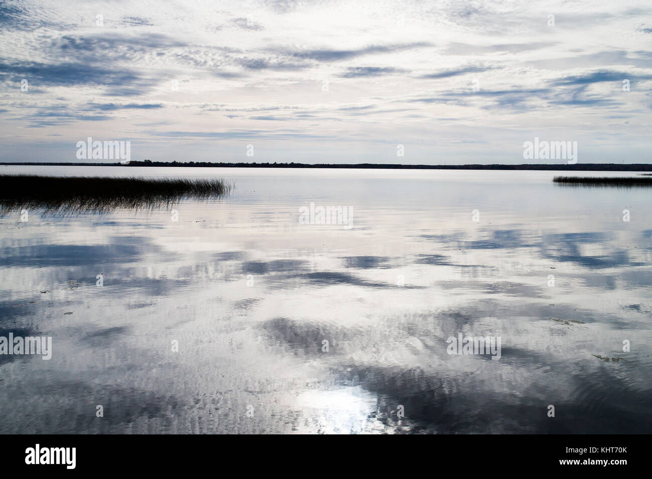 Sky and clouds reflecting in the lake at the end of the day. Stock Photo