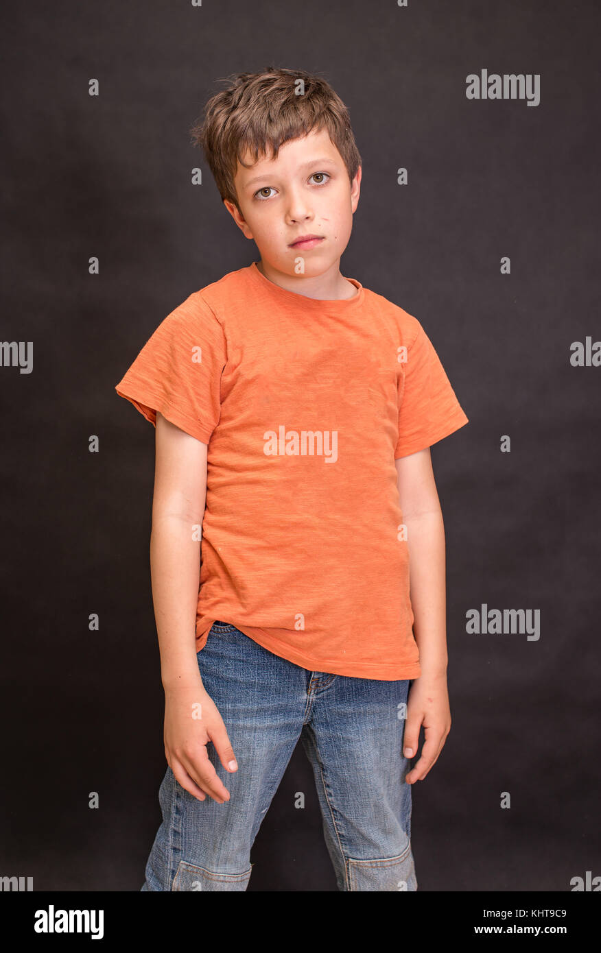 A boy portrait, young little cute and adorable kid, little obstreperous scamp. Poses, face expressions, ease, having fun, black background. Stock Photo