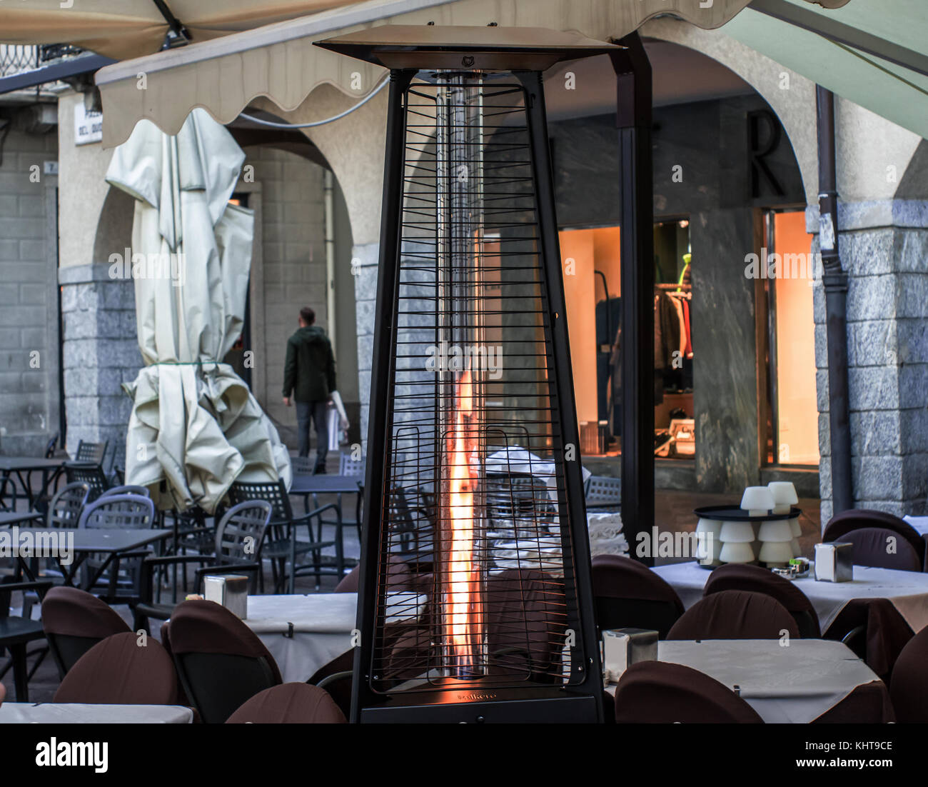 heating lamp placed among the tables of an open cafe Stock Photo
