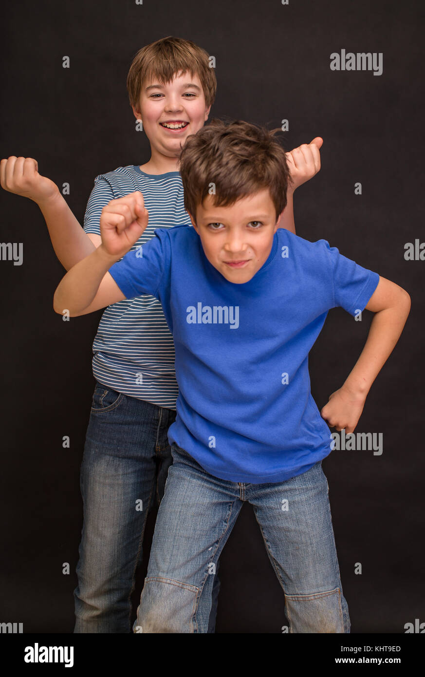 Brothers having fun whilst posing. Boys portrait, young little cute and adorable kids, little obstreperous scamps. Poses, face expressions, ease. Stock Photo