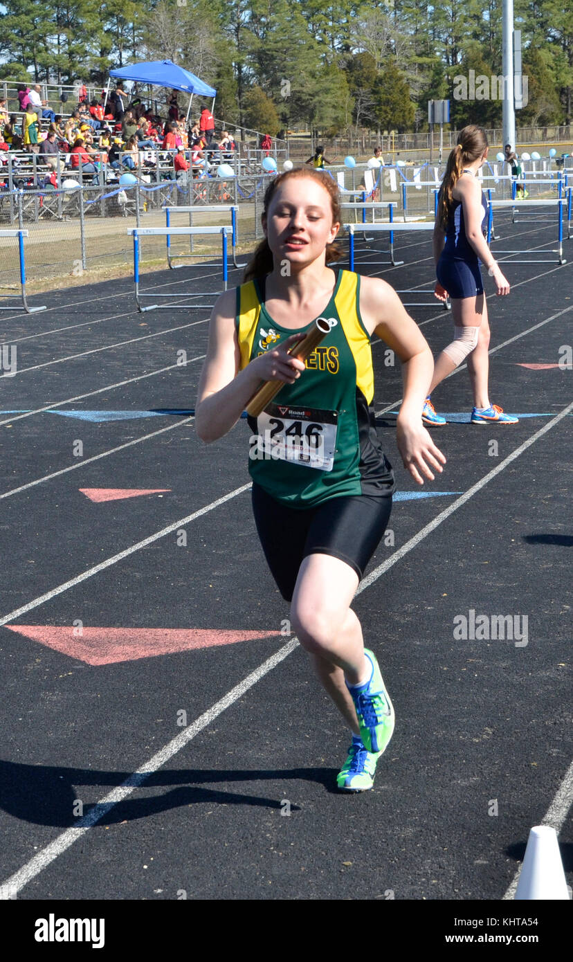 Girl in a relay race during track and field events Stock Photo