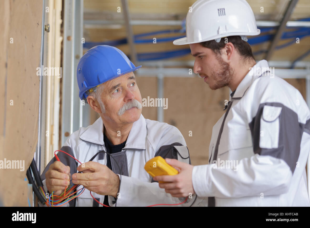 builders using a yellow multimeter to calibrate house Stock Photo Alamy