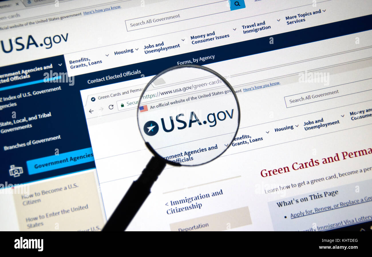 MONTREAL, CANADA - NOVEMBER 7, 2017: usa.gov website with green card regulations page under magnifying glass. The site is an official website of the U Stock Photo