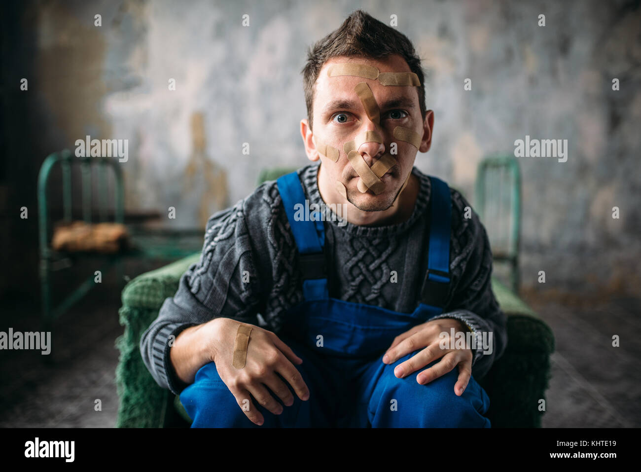 Madman in uniform mouth sealed with plaster, psycho patient. Mentally ill people concept, crazy human Stock Photo