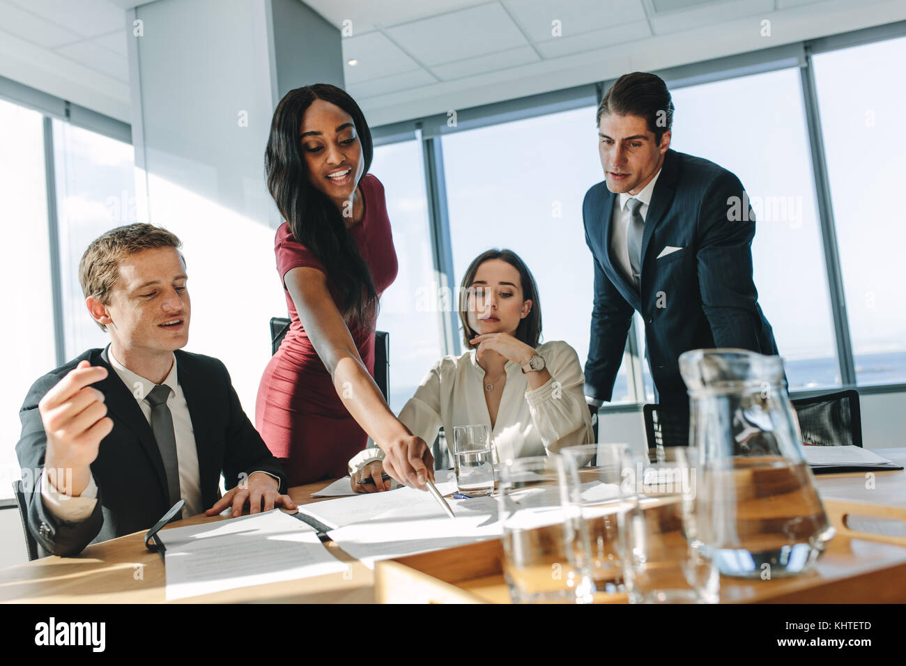 Female executive pointing at a paper on table and putting her ideas ...