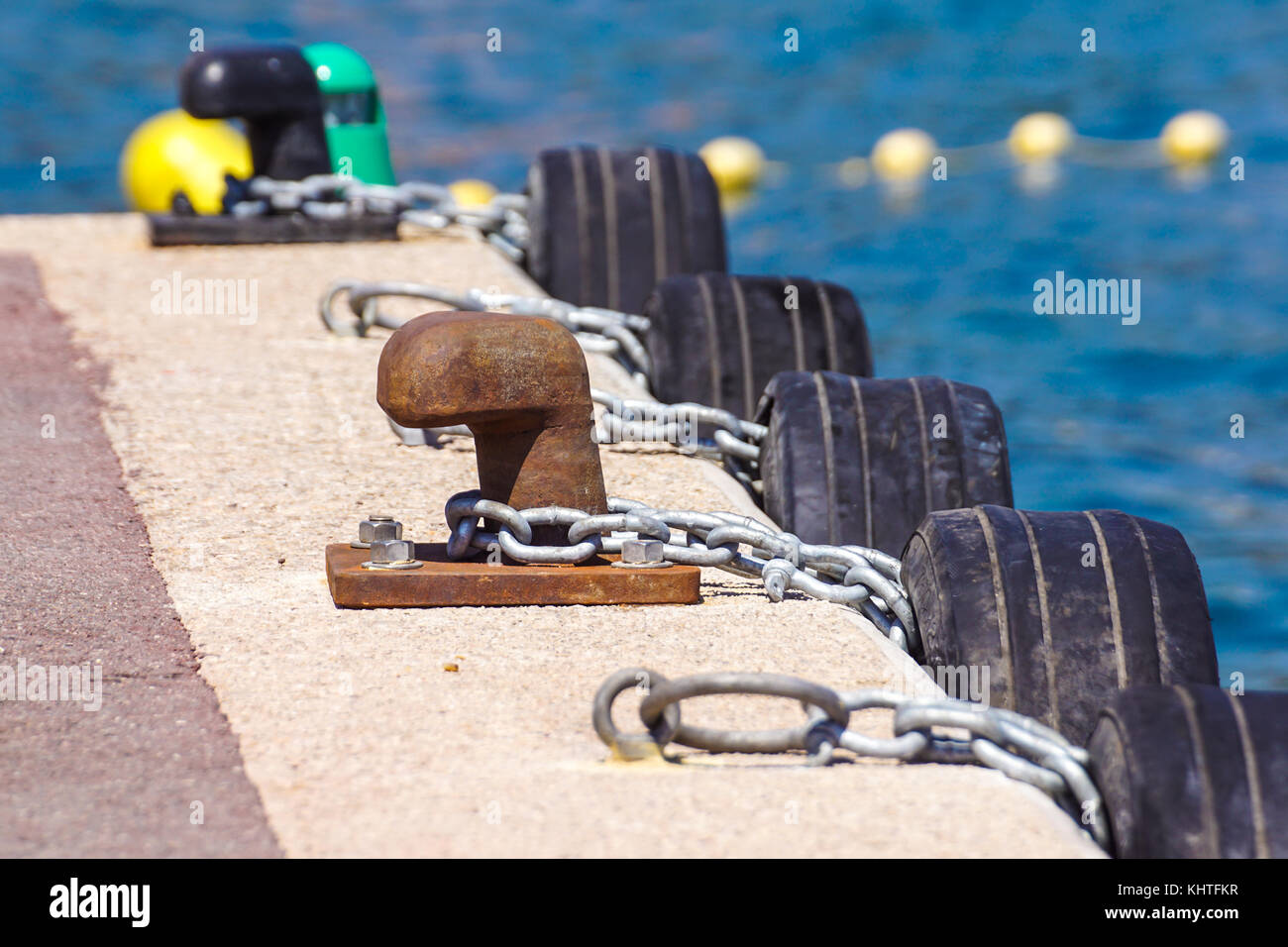 Old metal dock mooring pole with ring and rope for securing fishing
