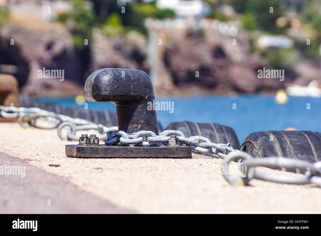 Old metal dock mooring pole with ring and rope for securing fishing