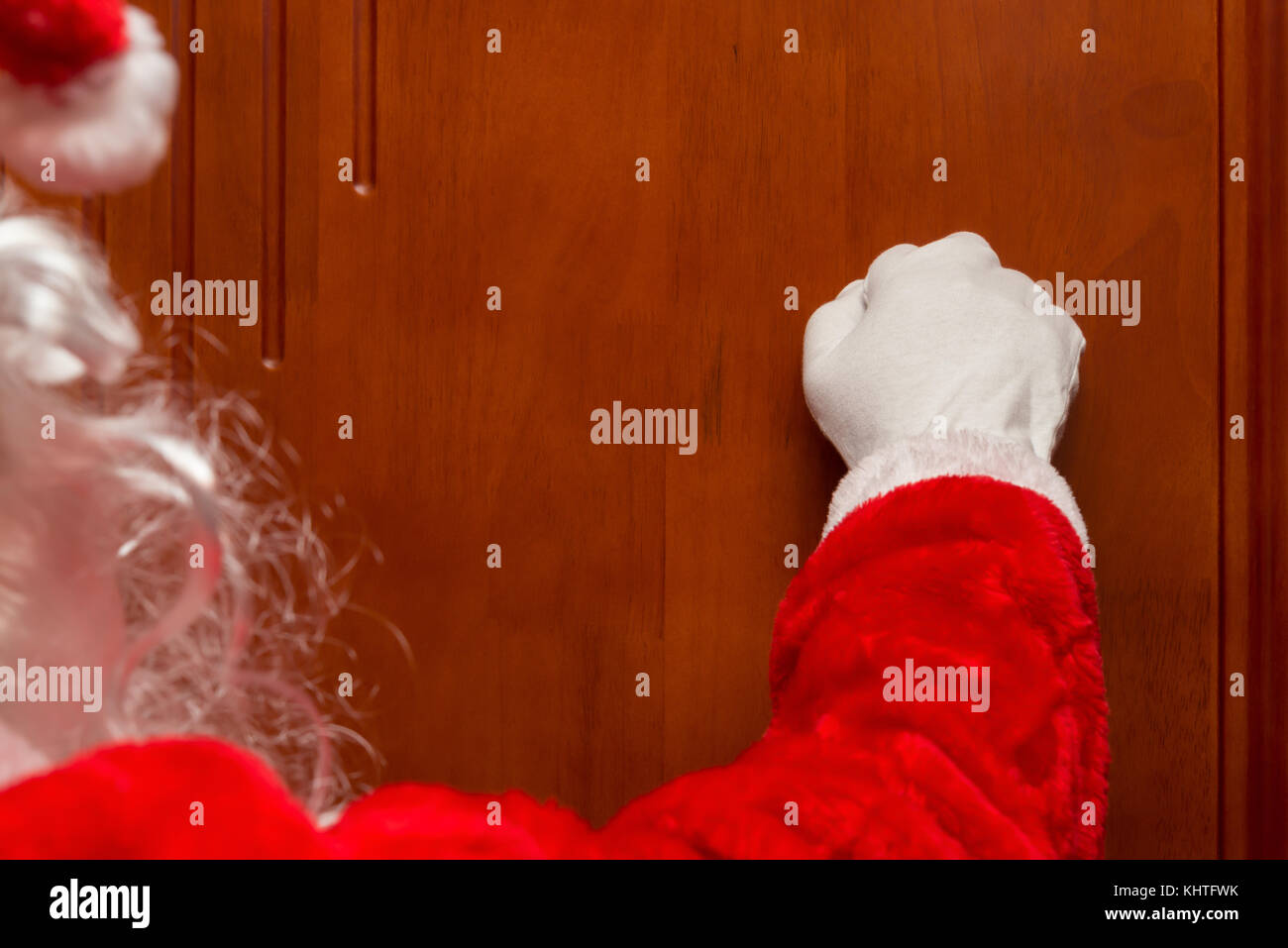 Santa Claus knocking the door Stock Photo