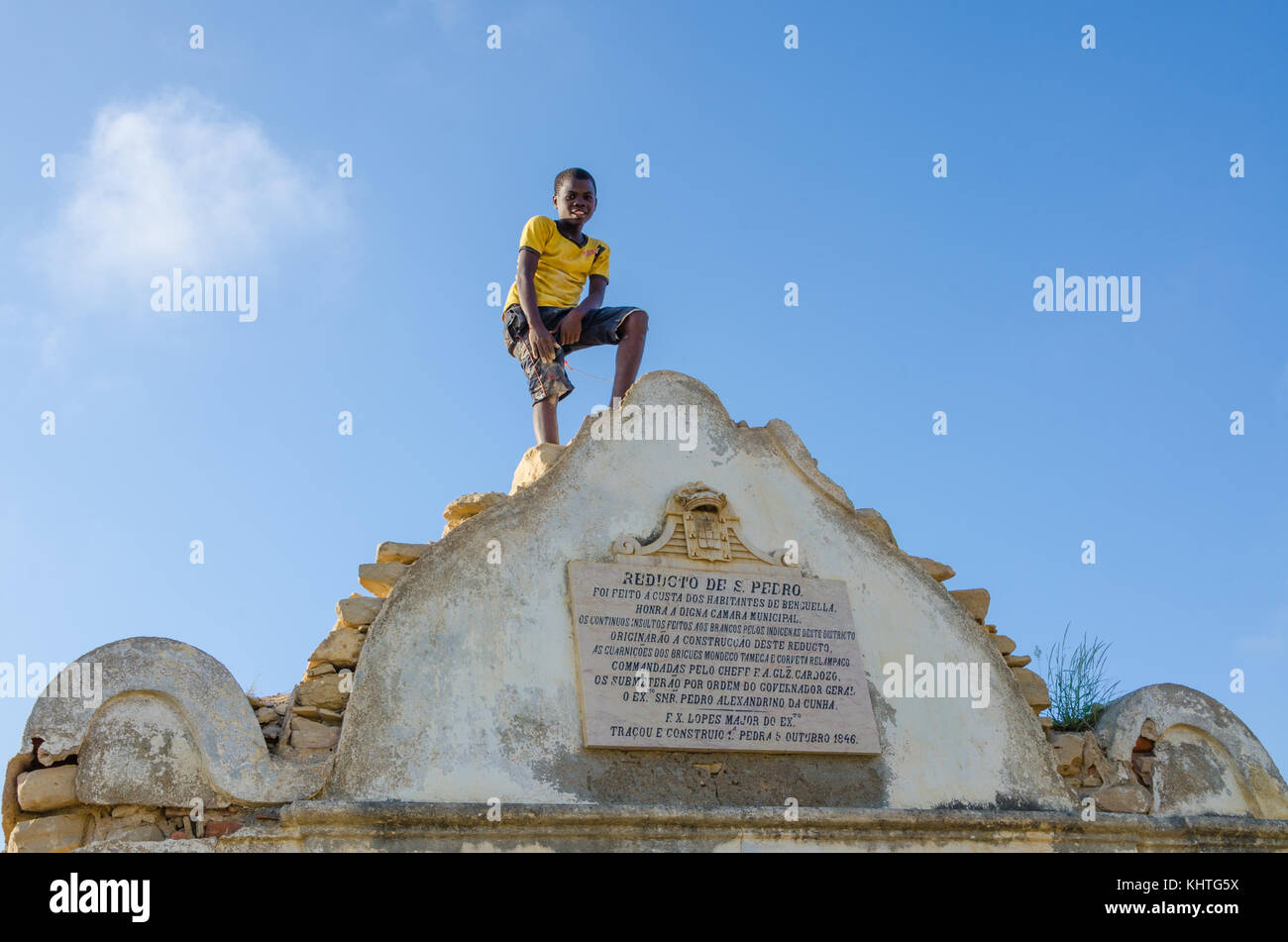 LOBITO, ANGOLA - MAY 09 2014: Unidentified African boy with yellow shirt standing on Reducto Sao Pedro Portuguese fort Stock Photo