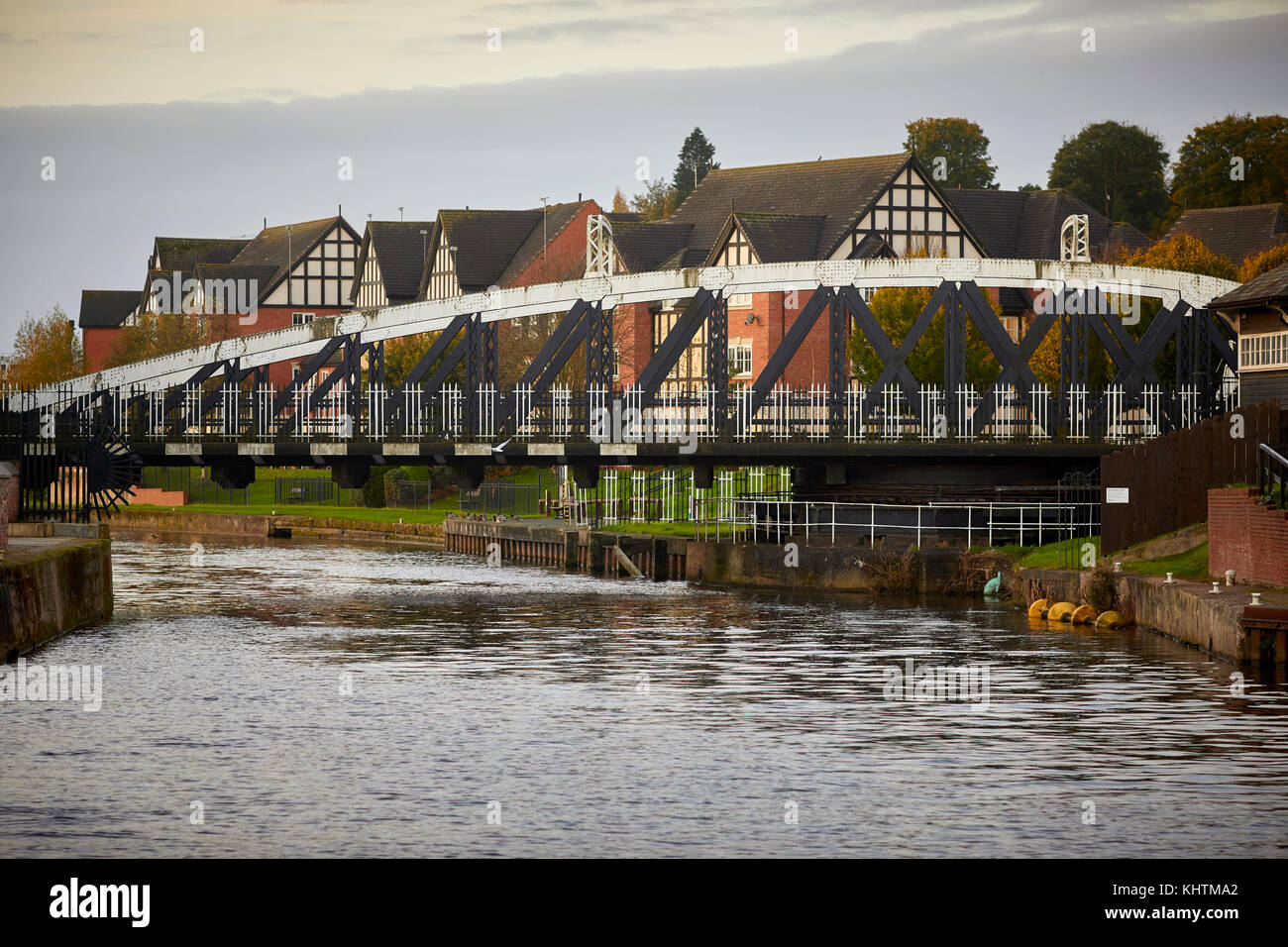 Canal boats floating on the River Weaver with golden autumn trees in the landscape and the Northwhich Town Swing Bridge in the background, Northwich i Stock Photo