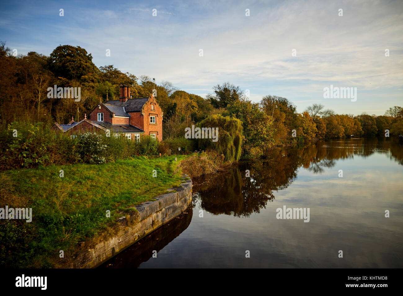 A Autumn landscape featuring a large brick house on the banks of the River Weaver in Northwich, Cheshire. Stock Photo