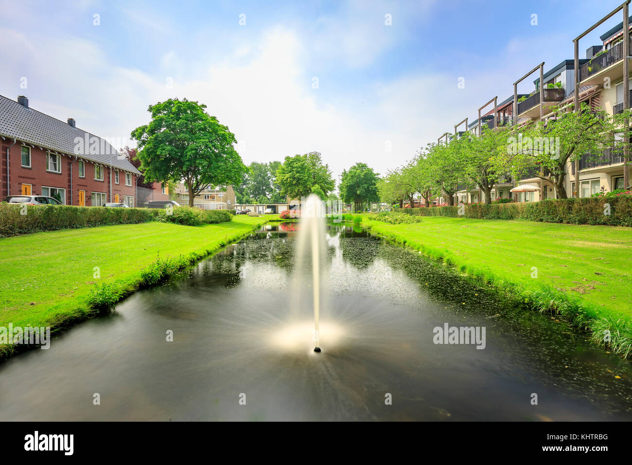 Attractive, decorative water fountain in a pond next to residential