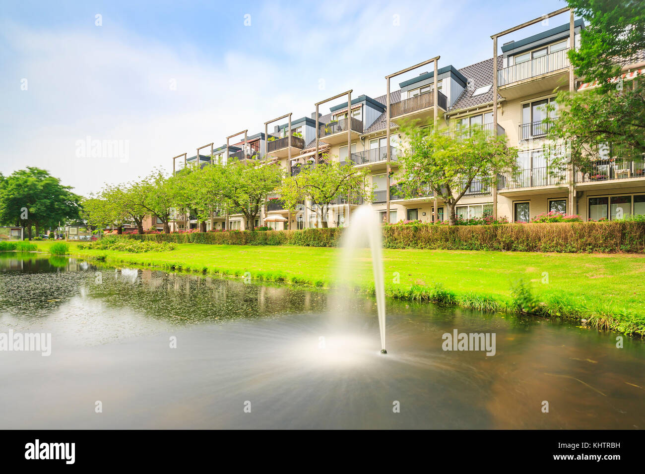 Attractive, decorative water fountain in a pond next to residential