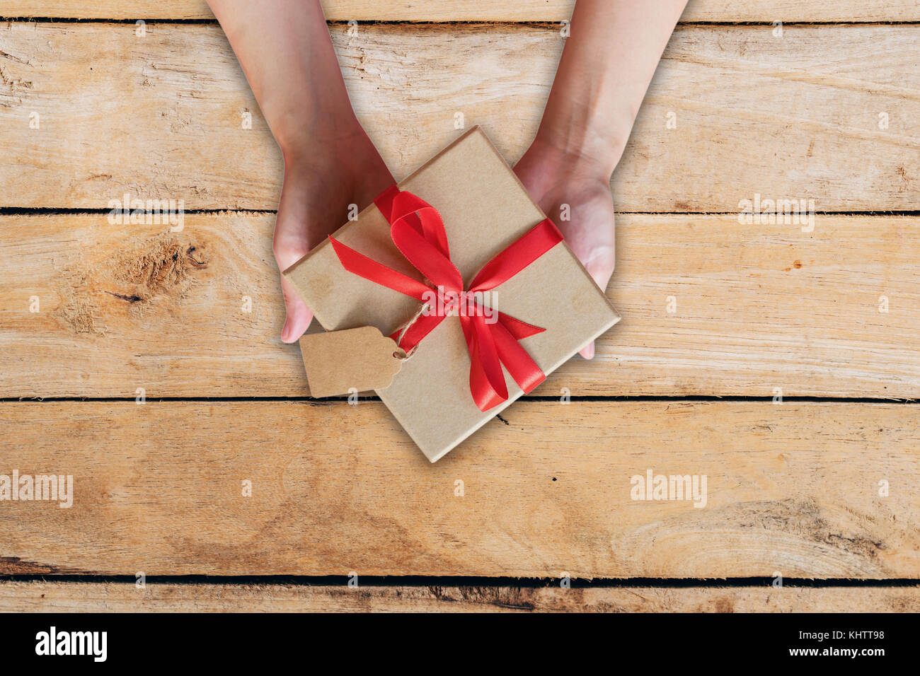 top view hand woman holding gift box on wood table. Stock Photo