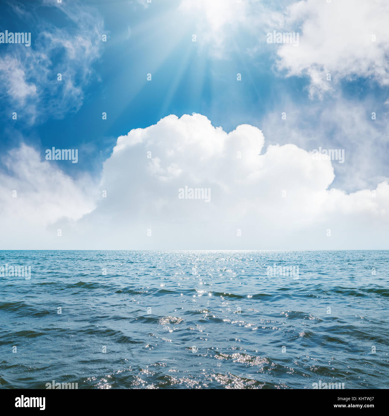 sun in blue sky with clouds over sea Stock Photo - Alamy