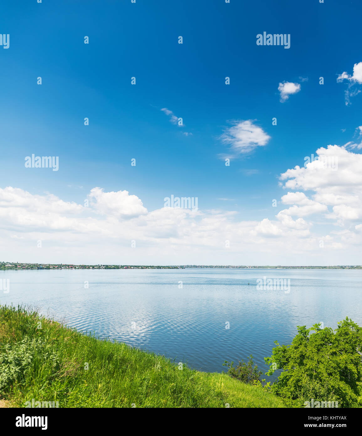 deep blue sky with clouds over river and green grass Stock Photo - Alamy