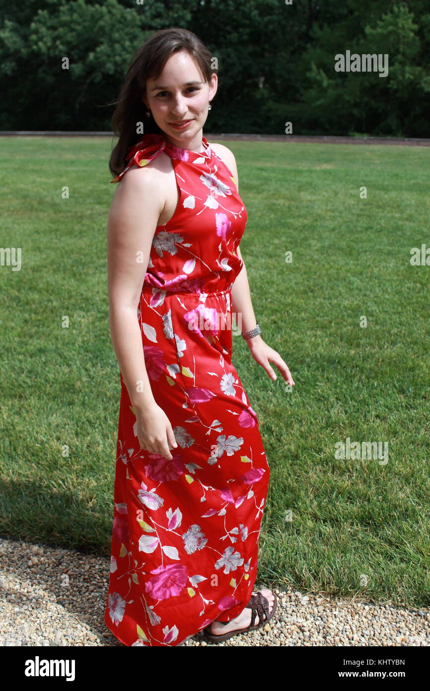 A woman in a full length red dress standing outside Stock Photo - Alamy