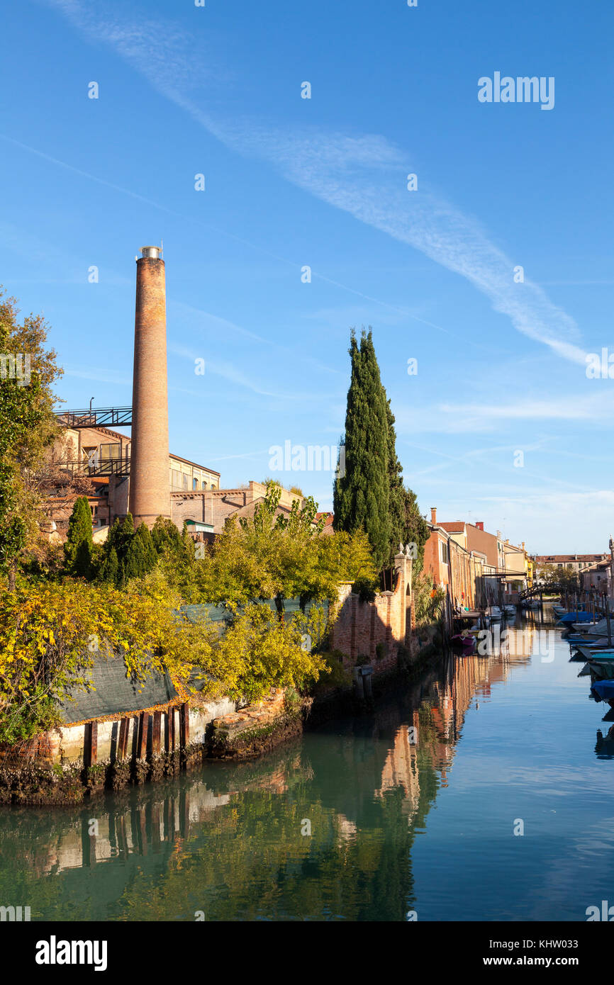 Converted industrial architecture, Giudecca, Venice, Italy at sunset on a tranquil side canal of Rio di San Biagio Stock Photo