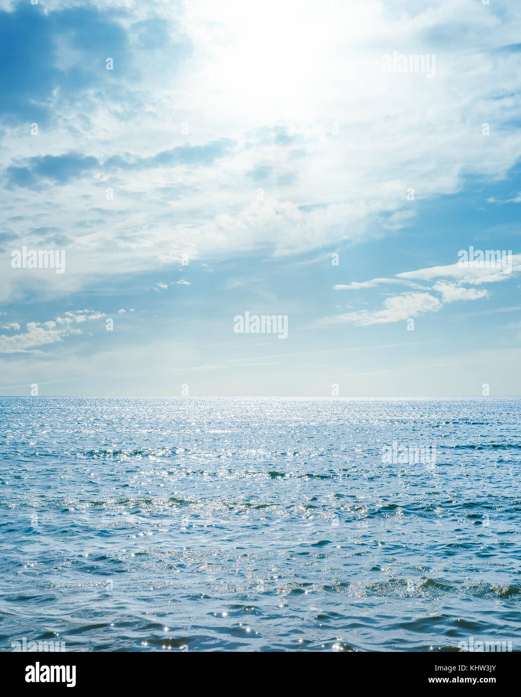 sun in blue sky with clouds over sea Stock Photo - Alamy
