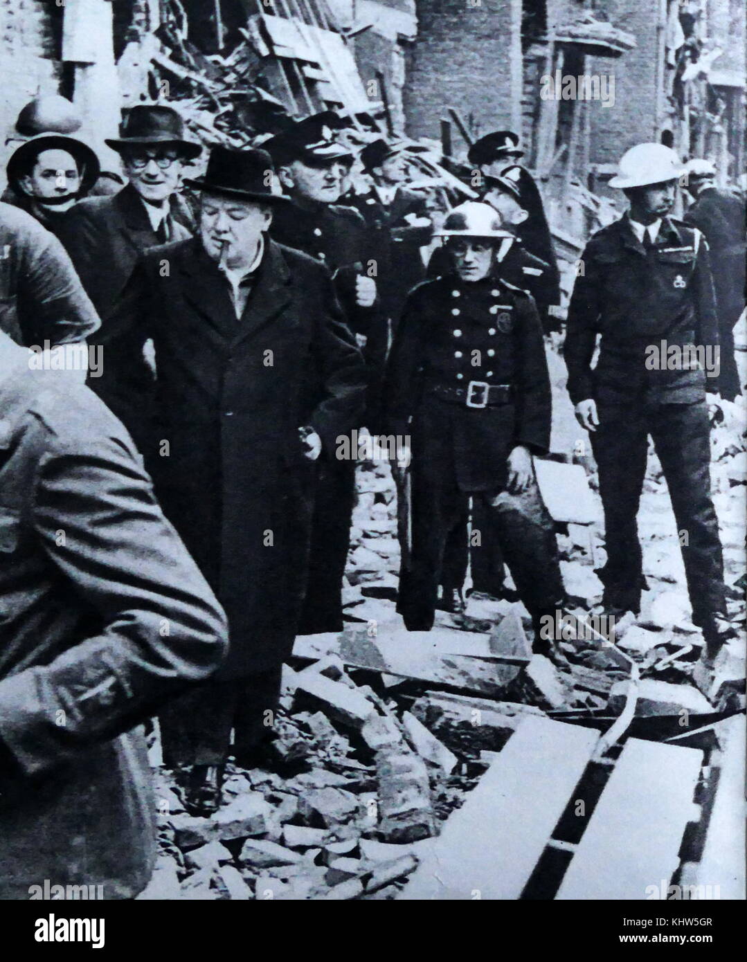 Photograph of Sir Winston Churchill walking amongst the rubble of homes as a result of an air raid on London. Sir Winston Leonard Spencer-Churchill (1874-1965) a British politician and Prime Minister of the United Kingdom. Dated 20th Century Stock Photo