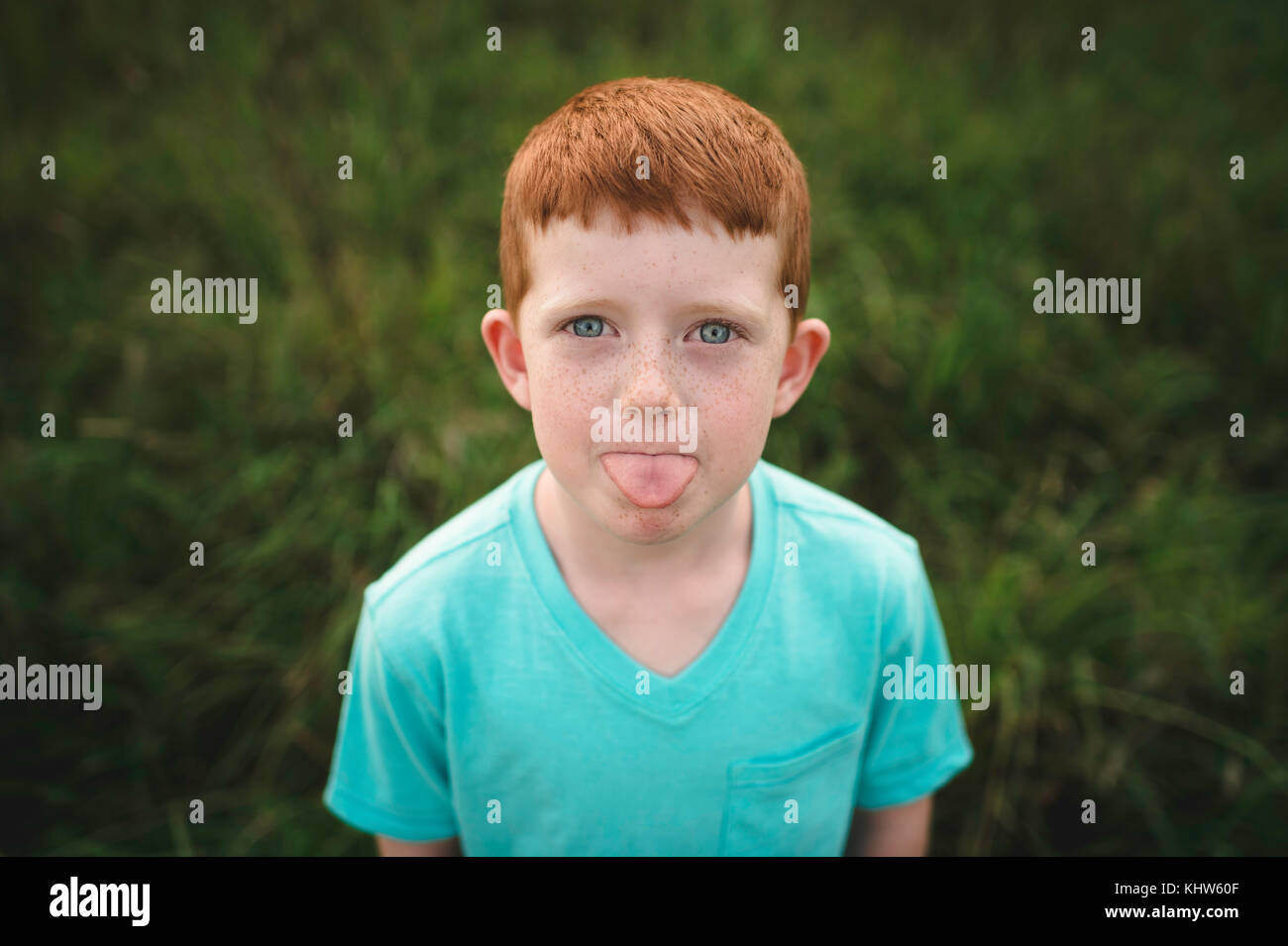 Portrait of red haired boy sticking out tongue Stock Photo