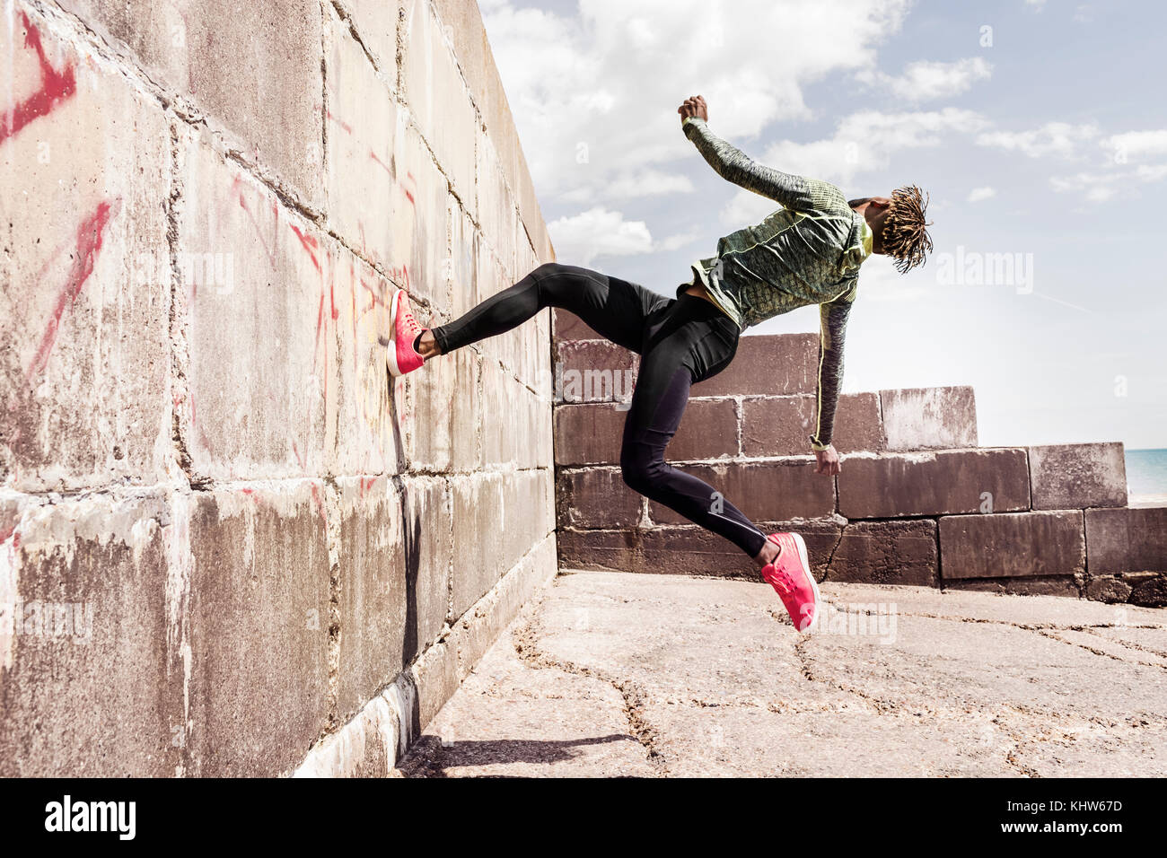 Young man, free running, outdoors, running up side of wall Stock Photo