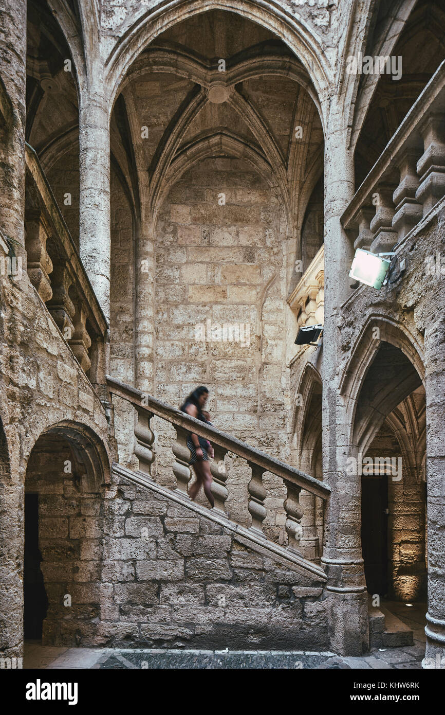 Female tourist and baby moving down church stairway, Pezenas, Occitanie region, France Stock Photo