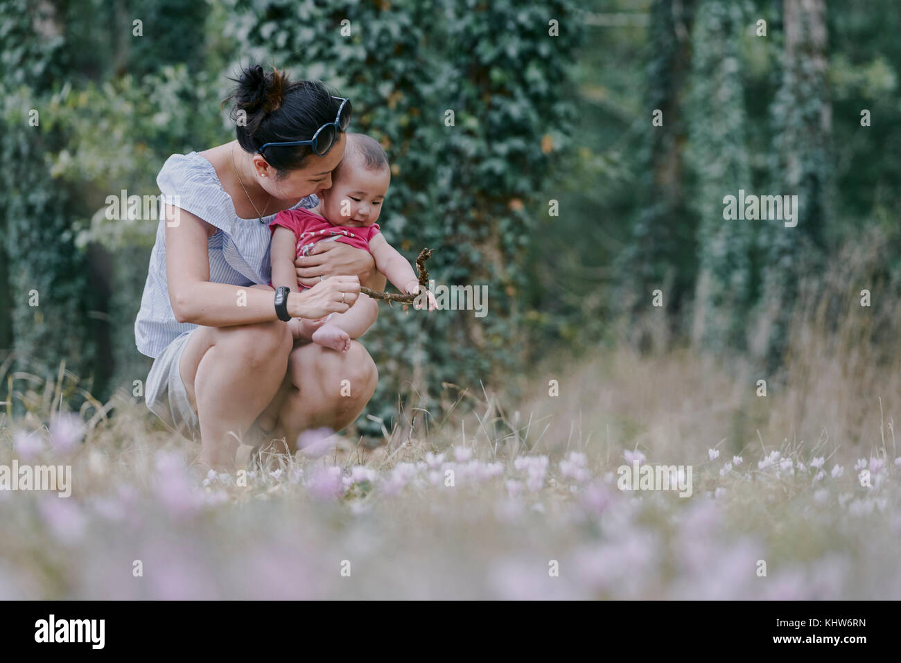 Woman crouching with baby daughter in park, Chenonceaux, Loire Valley, France Stock Photo