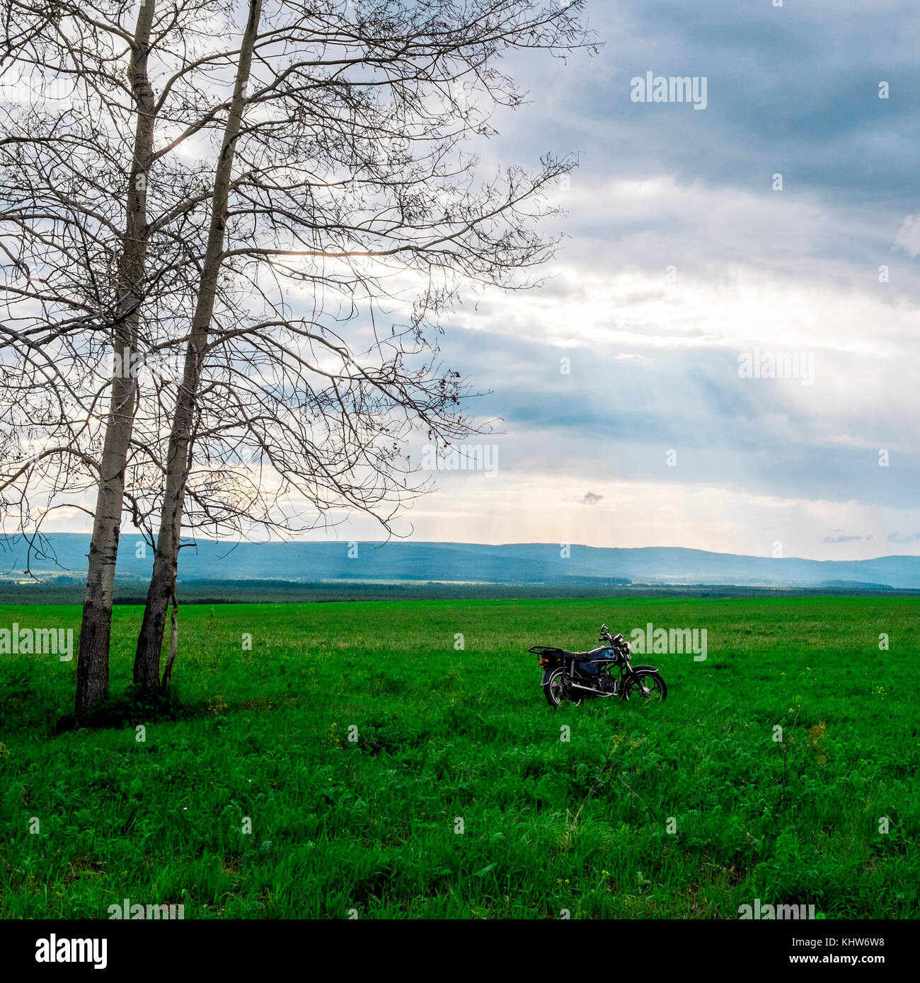 Motorbike on grassy field, Ural, Sverdlovsk, Russia Stock Photo