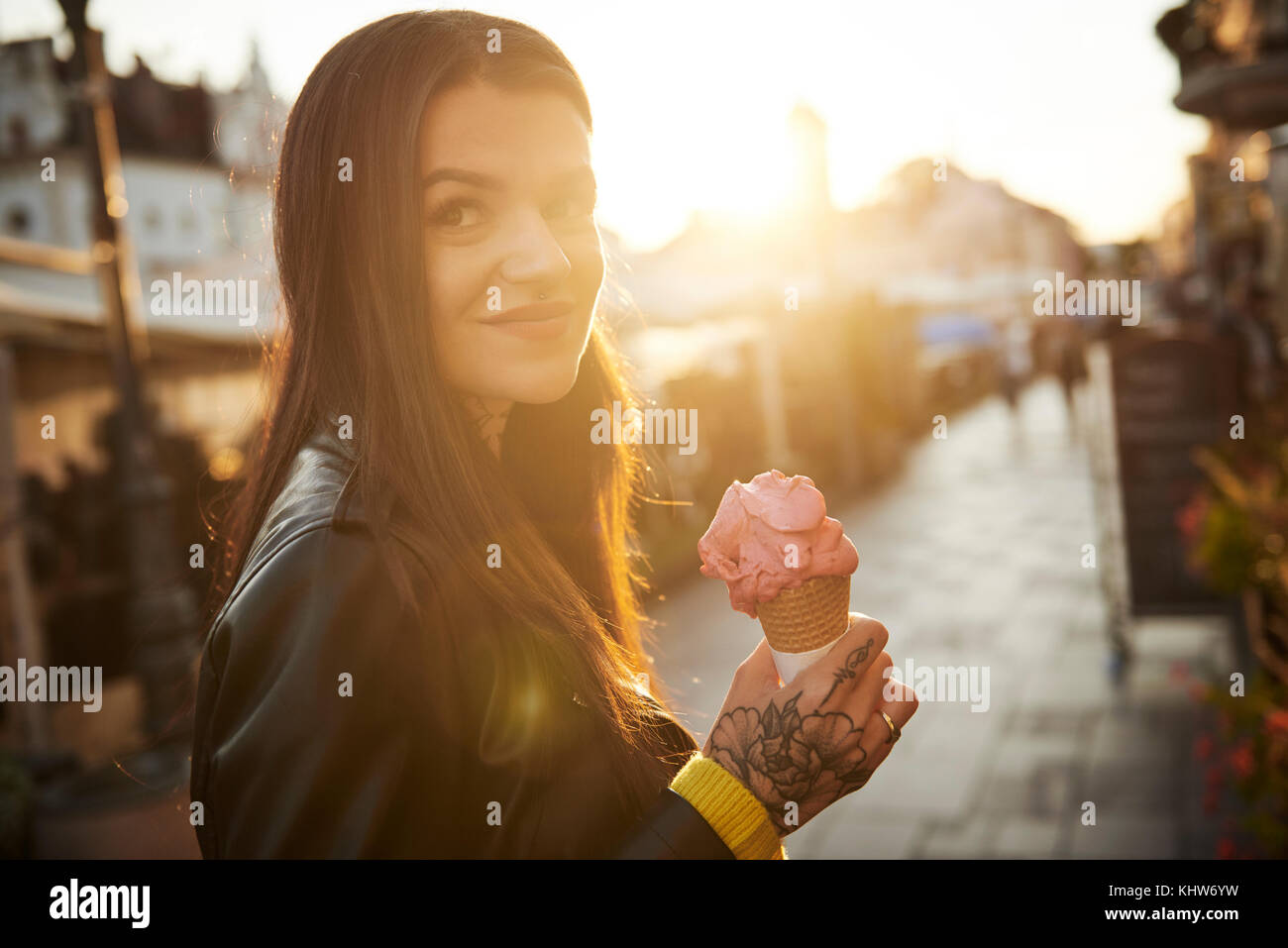 Portrait of young woman holding ice cream, tattoos on hand Stock Photo