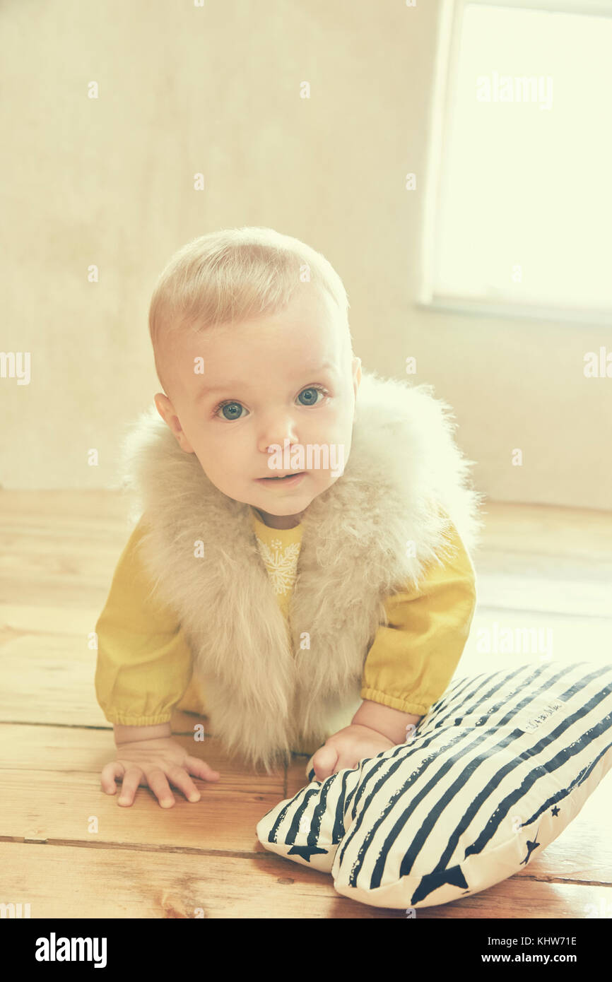 Portrait of baby girl crawling on floorboards Stock Photo