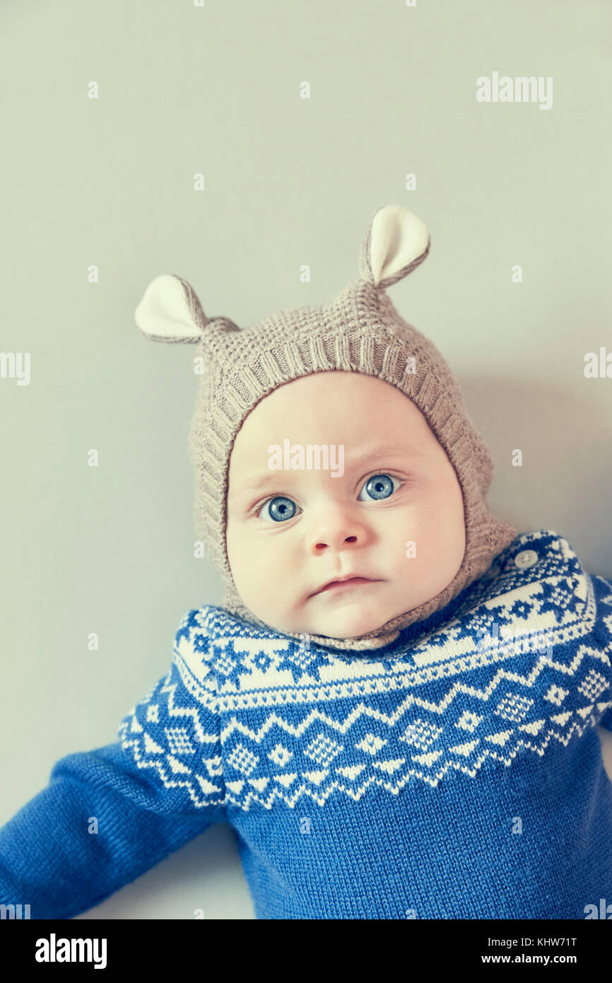 Portrait of blue eyed baby boy in knitted hat with ears Stock Photo